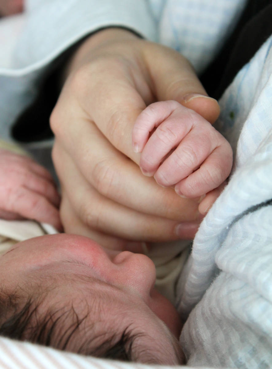Kleine Babyhand in der Hand der Mutter